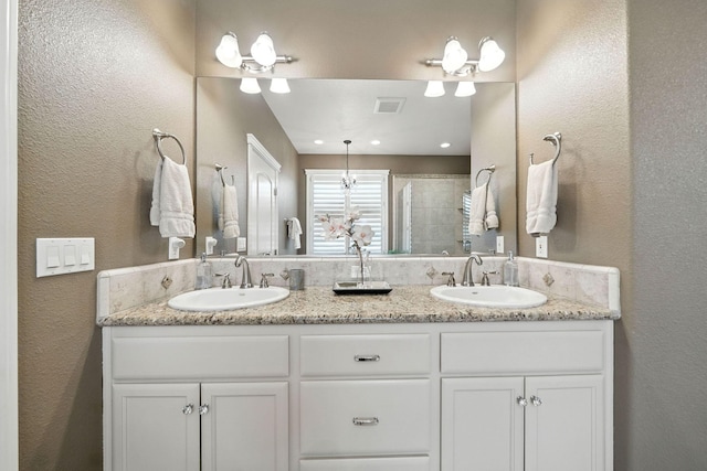 2110 Cilantro Dr, Redding, CA 96003 - bathroom featuring double vanity, a textured wall, and tiled shower