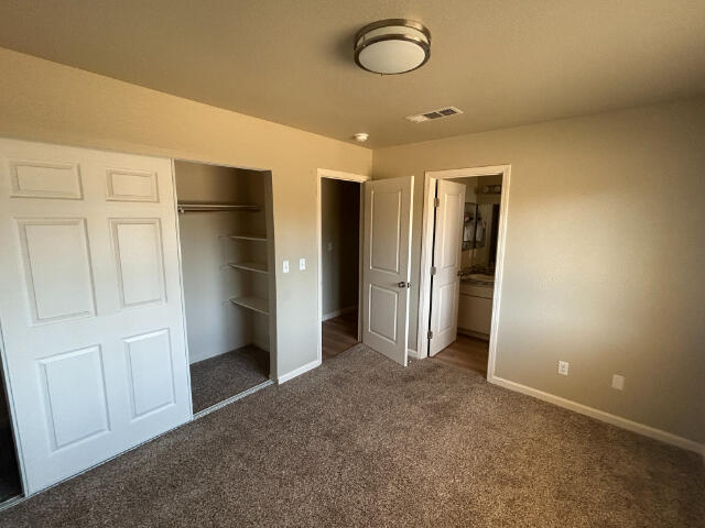 3995 Vassar Way, Shasta Lake, CA 96019 - unfurnished bedroom featuring carpet floors, a closet, and connected bathroom