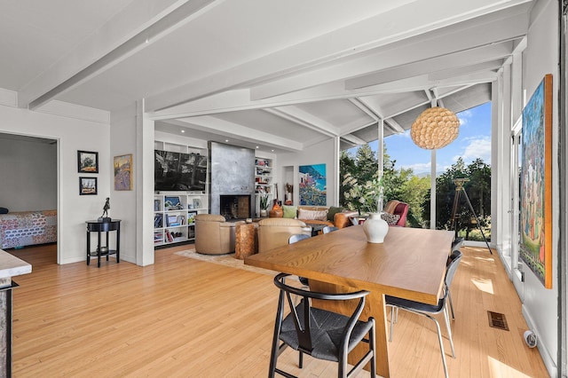 3540 Scenic Dr, Redding, CA 96001 - dining area with beam ceiling, a fireplace, and light wood-style floors