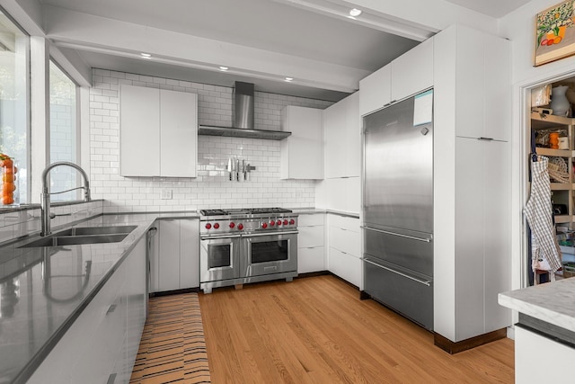 3540 Scenic Dr, Redding, CA 96001 - kitchen featuring high quality appliances, wall chimney exhaust hood, backsplash, light wood finished floors, and recessed lighting