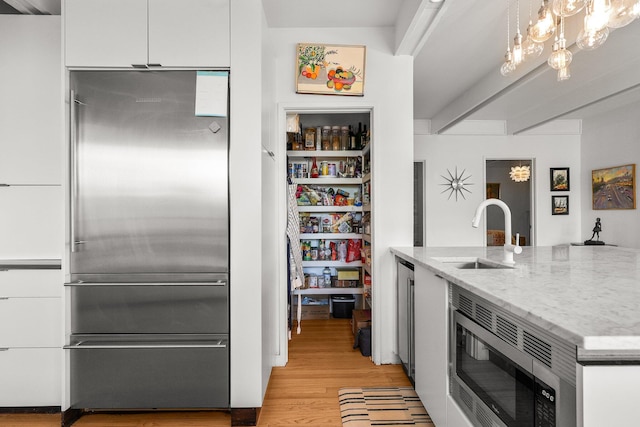 3540 Scenic Dr, Redding, CA 96001 - kitchen featuring appliances with stainless steel finishes, white cabinetry, light wood-style floors, light stone countertops, and hanging light fixtures