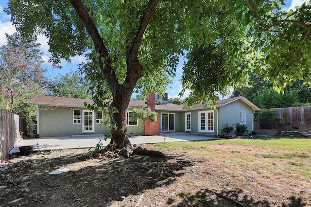 2920 Pioneer Dr, Redding, CA 96001 - back of property featuring french doors, stucco siding, a patio, and a chimney