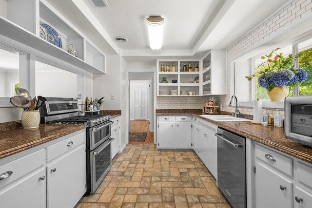 2920 Pioneer Dr, Redding, CA 96001 - kitchen with appliances with stainless steel finishes, open shelves, decorative backsplash, and white cabinetry