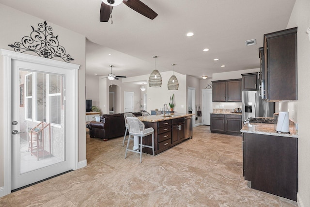 4075 Pembroke Ln, Shasta Lake, CA 96019 - kitchen with a ceiling fan, dark brown cabinets, a kitchen breakfast bar, stainless steel appliances, and recessed lighting
