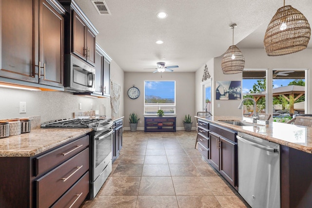 4075 Pembroke Ln, Shasta Lake, CA 96019 - kitchen featuring stainless steel appliances, dark brown cabinets, hanging light fixtures, a textured ceiling, and recessed lighting