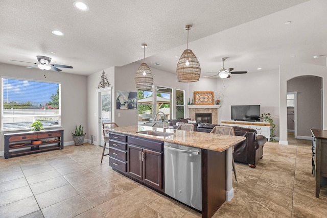 4075 Pembroke Ln, Shasta Lake, CA 96019 - kitchen with dishwasher, a ceiling fan, arched walkways, a fireplace, and light stone countertops