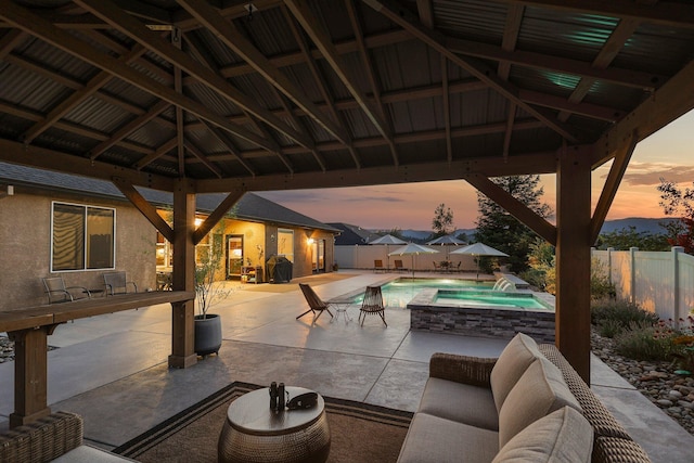 4075 Pembroke Ln, Shasta Lake, CA 96019 - patio terrace at dusk with a gazebo, a patio, a fenced backyard, a pool with connected hot tub, and outdoor lounge area