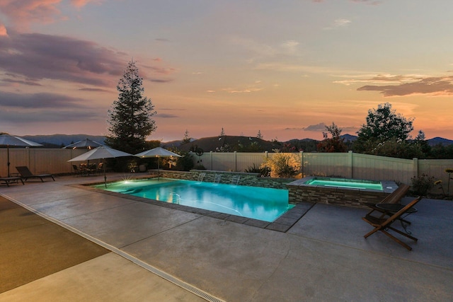 4075 Pembroke Ln, Shasta Lake, CA 96019 - pool at dusk with a patio area, a fenced backyard, and a pool with connected hot tub