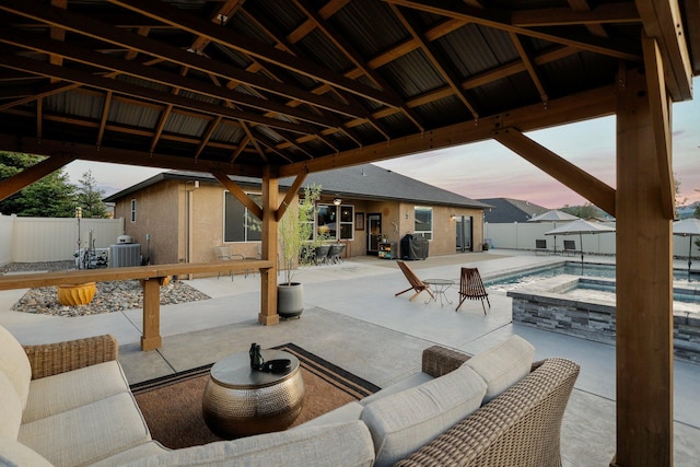 4075 Pembroke Ln, Shasta Lake, CA 96019 - patio terrace at dusk with a gazebo, a patio area, a fenced backyard, a pool with connected hot tub, and an outdoor living space