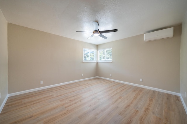 4725 Cedars Rd, Redding, CA 96001 - empty room with an AC wall unit, a ceiling fan, light wood-type flooring, and a textured ceiling