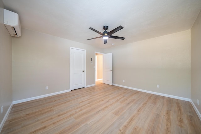 4725 Cedars Rd, Redding, CA 96001 - unfurnished bedroom featuring a wall mounted AC, light wood-style flooring, and ceiling fan