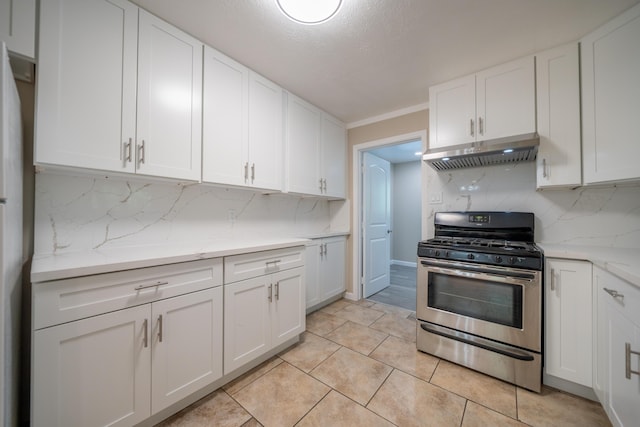 4725 Cedars Rd, Redding, CA 96001 - kitchen with stainless steel range with gas cooktop, under cabinet range hood, tasteful backsplash, white cabinetry, and light tile patterned flooring