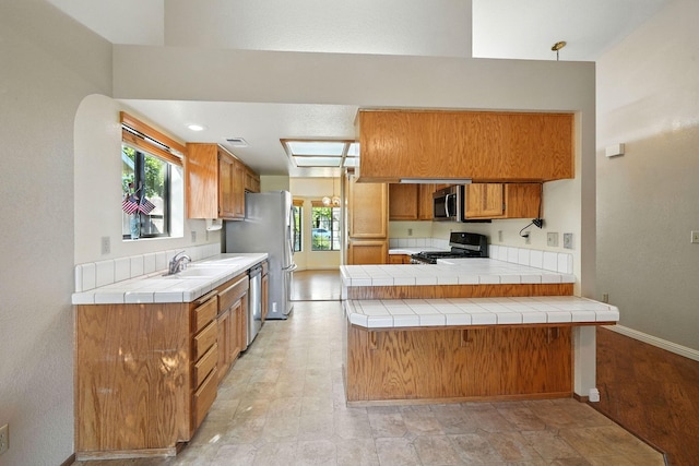 2585 Meadowview Dr, Red Bluff, CA 96080 - kitchen with stainless steel appliances, brown cabinets, tile countertops, and a peninsula