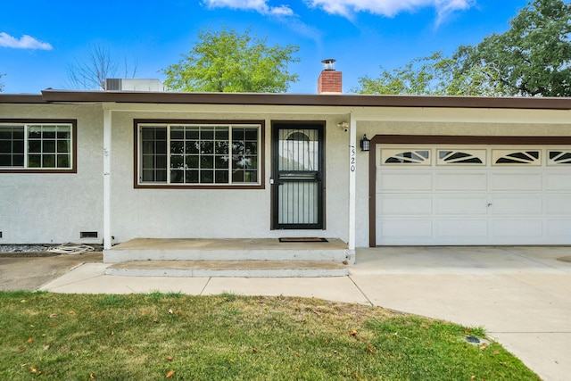 1520 Minor St, Redding, CA 96002 - property entrance with a chimney, stucco siding, driveway, and an attached garage