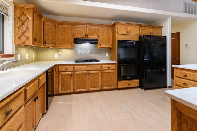 36088 Deer Flat Rd, Shingletown, CA 96088 - kitchen with black appliances, light wood-style floors, brown cabinets, and backsplash