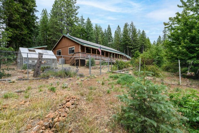 36088 Deer Flat Rd, Shingletown, CA 96088 - back of property featuring an exterior structure, an outdoor structure, a wooden deck, and a wooded view