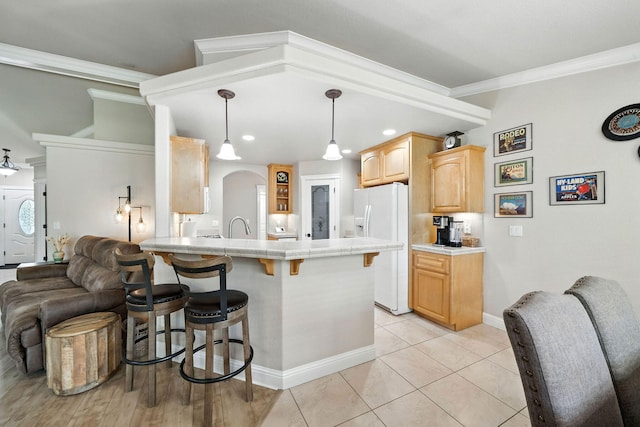 2072 Button Pl, Redding, CA 96002 - kitchen featuring white refrigerator with ice dispenser, a peninsula, a breakfast bar, light brown cabinets, and open floor plan