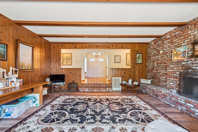 14480 Warren Ave, Red Bluff, CA 96080 - living room featuring beamed ceiling, wood finished floors, a chandelier, wooden walls, and a fireplace