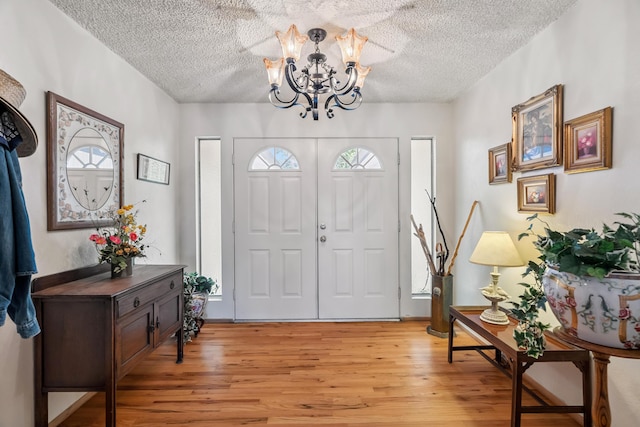 14480 Warren Ave, Red Bluff, CA 96080 - foyer entrance with light wood-style floors, a textured ceiling, and a chandelier