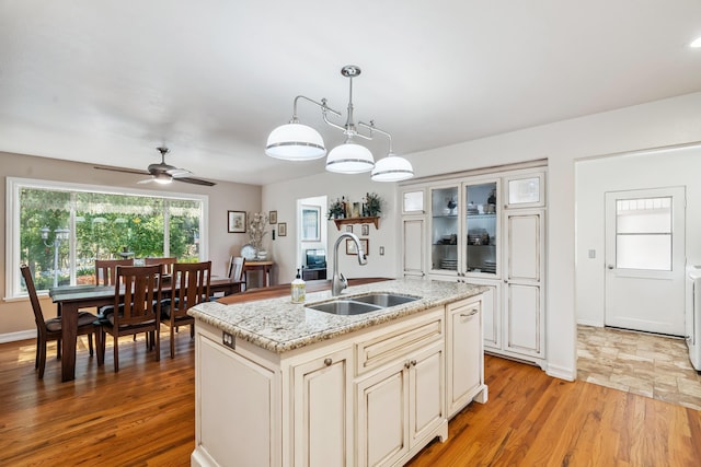 14480 Warren Ave, Red Bluff, CA 96080 - kitchen with light wood finished floors, ceiling fan, pendant lighting, glass insert cabinets, and a center island with sink