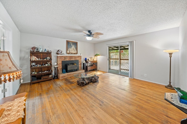 4215 Oro St, Redding, CA 96002 - living area with wood finished floors, a textured ceiling, ceiling fan, and a brick fireplace