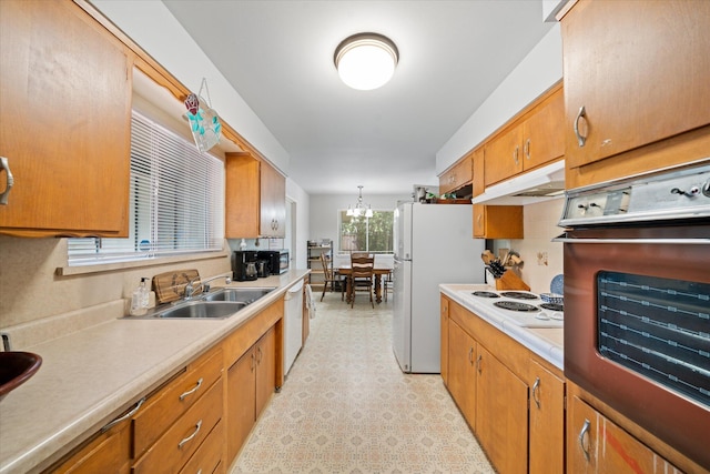 4215 Oro St, Redding, CA 96002 - kitchen with white appliances, under cabinet range hood, light countertops, brown cabinetry, and light floors