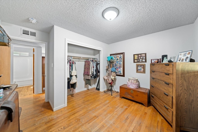 4215 Oro St, Redding, CA 96002 - bedroom with light wood-type flooring, a closet, and a textured ceiling