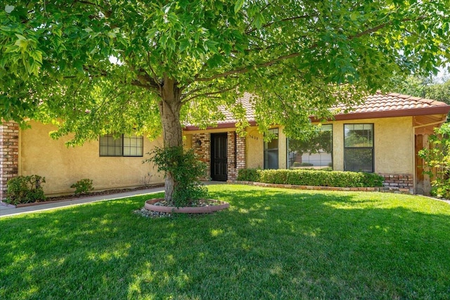 3628 Somerset Ave, Redding, CA 96002 - view of front of house with stucco siding, a front lawn, and a tile roof