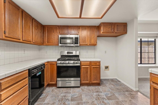 3628 Somerset Ave, Redding, CA 96002 - kitchen featuring stainless steel appliances, brown cabinets, tasteful backsplash, and tile countertops