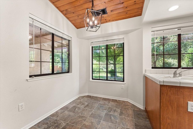 3628 Somerset Ave, Redding, CA 96002 - unfurnished dining area featuring wood ceiling, a chandelier, and dark stone finish floors