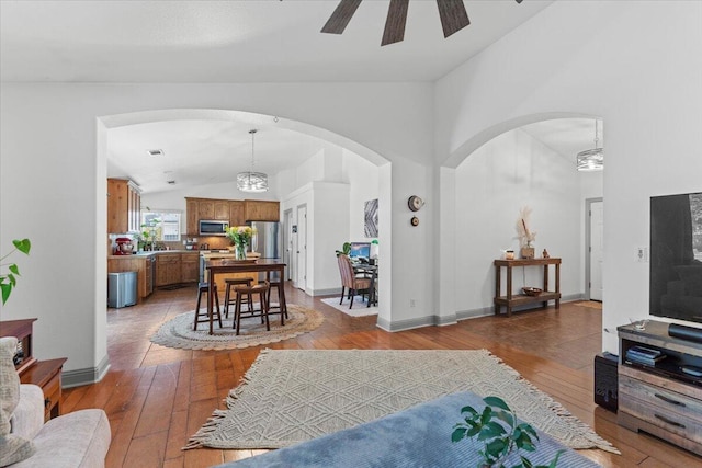 2236 Lonigan Ct, Redding, CA 96001 - living room featuring hardwood / wood-style flooring, arched walkways, ceiling fan, and high vaulted ceiling