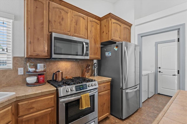 2236 Lonigan Ct, Redding, CA 96001 - kitchen featuring stainless steel appliances, washing machine and clothes dryer, backsplash, and plenty of natural light