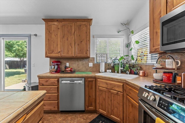 2236 Lonigan Ct, Redding, CA 96001 - kitchen featuring stainless steel appliances, tile counters, backsplash, and brown cabinets
