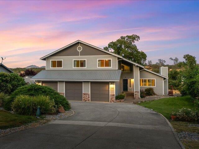 15540 China Rapids Dr, Red Bluff, CA 96080 - view of front of home featuring driveway, a garage, and stone siding