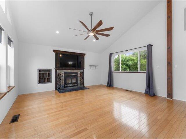 15540 China Rapids Dr, Red Bluff, CA 96080 - unfurnished living room featuring a ceiling fan, high vaulted ceiling, a fireplace with flush hearth, light wood-type flooring, and recessed lighting