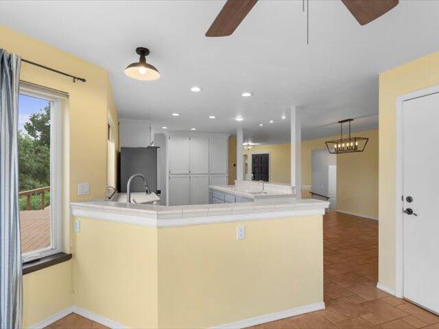 15540 China Rapids Dr, Red Bluff, CA 96080 - kitchen featuring a ceiling fan, light countertops, recessed lighting, a peninsula, and freestanding refrigerator