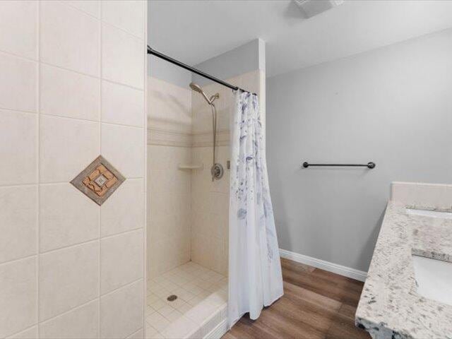 15540 China Rapids Dr, Red Bluff, CA 96080 - full bathroom with a tile shower, vanity, and wood finished floors