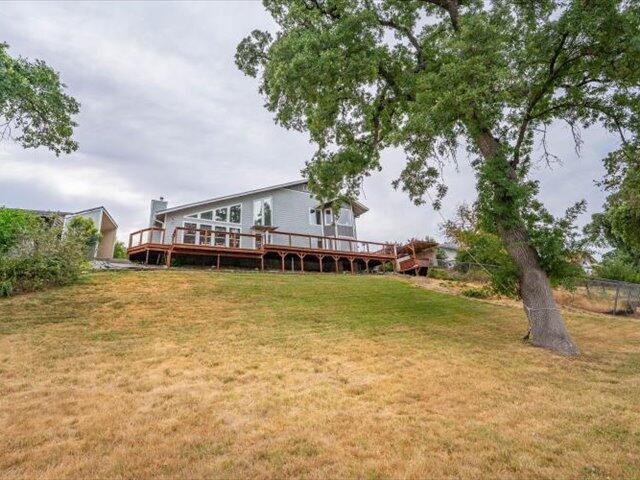15540 China Rapids Dr, Red Bluff, CA 96080 - rear view of property with a wooden deck and a lawn