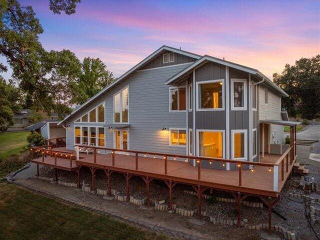 15540 China Rapids Dr, Red Bluff, CA 96080 - back of property at dusk with a deck and board and batten siding