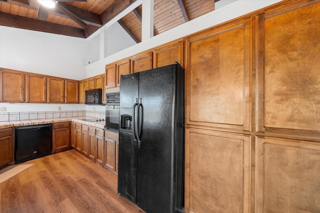 3400 Hillcrest St, Redding, CA 96001 - kitchen with black appliances, a wood ceiling with exposed beams, light wood-type flooring, brown cabinets, and light countertops