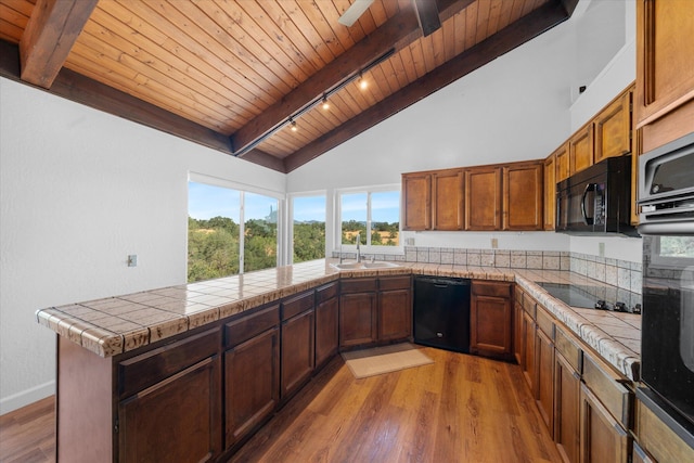 3400 Hillcrest St, Redding, CA 96001 - kitchen with black appliances, a wood ceiling with exposed beams, light wood finished floors, a peninsula, and high vaulted ceiling