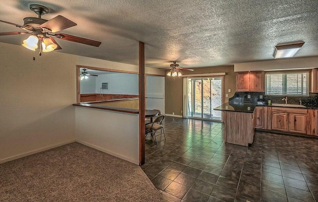 21657 W Elk Trl, Redding, CA 96003 - kitchen with a ceiling fan, healthy amount of natural light, dark countertops, backsplash, and a textured ceiling