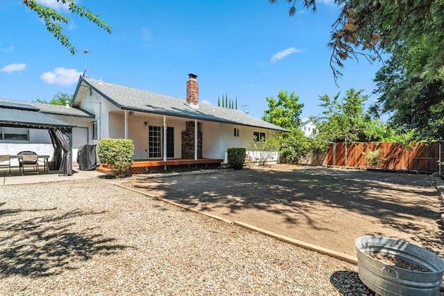 3442 Thomas Ave, Anderson, CA 96007 - rear view of property featuring a chimney, stucco siding, a gazebo, a wooden deck, and a patio area