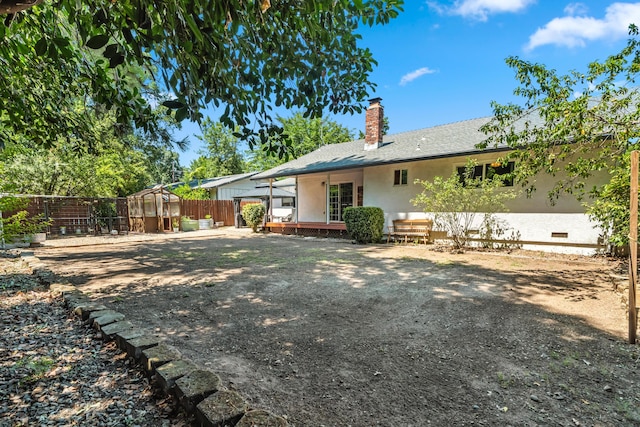 3442 Thomas Ave, Anderson, CA 96007 - back of house featuring a chimney, stucco siding, and an exterior structure