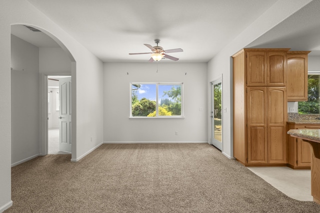 19258 Granola Way, Cottonwood, CA 96022 - unfurnished living room featuring light carpet, ceiling fan, arched walkways, and plenty of natural light