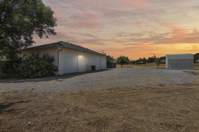 19258 Granola Way, Cottonwood, CA 96022 - property exterior at dusk with an outdoor structure, a garage, and stucco siding