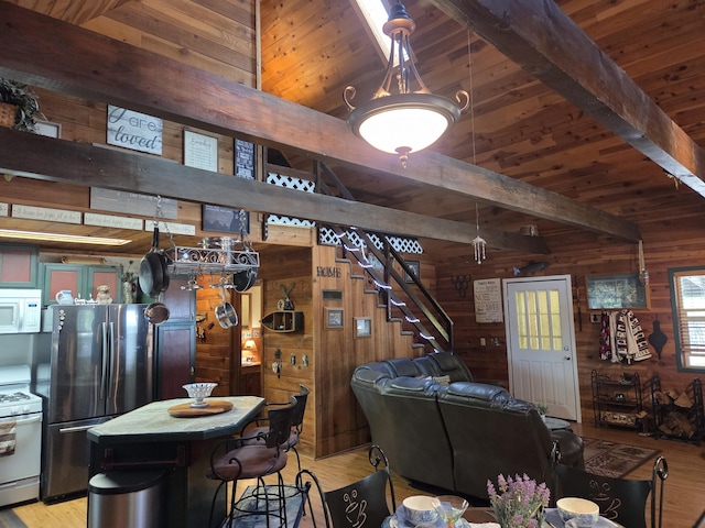 8421 Starlite Pines Rd, Shingletown, CA 96088 - living room with wood walls, light wood finished floors, and a wood ceiling with exposed beams