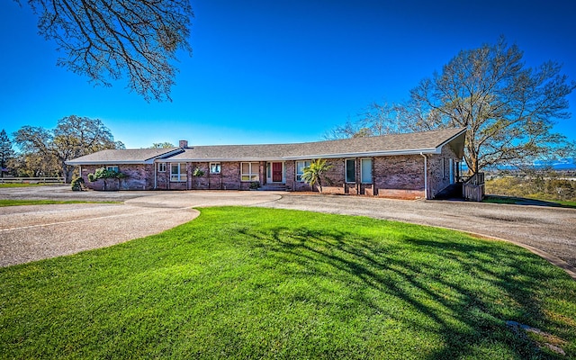 21790 Adobe Rd, Red Bluff, CA 96080 - ranch-style house with brick siding, curved driveway, a front lawn, and a chimney