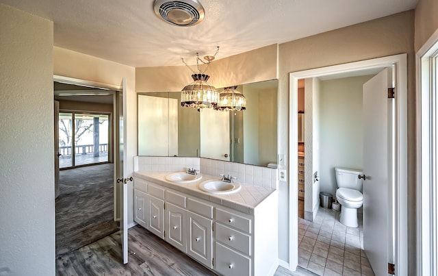 21790 Adobe Rd, Red Bluff, CA 96080 - bathroom featuring double vanity, a chandelier, decorative backsplash, and wood finished floors
