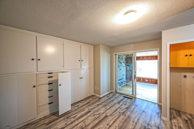 21790 Adobe Rd, Red Bluff, CA 96080 - unfurnished bedroom with wood finished floors, a textured ceiling, access to outside, and a closet